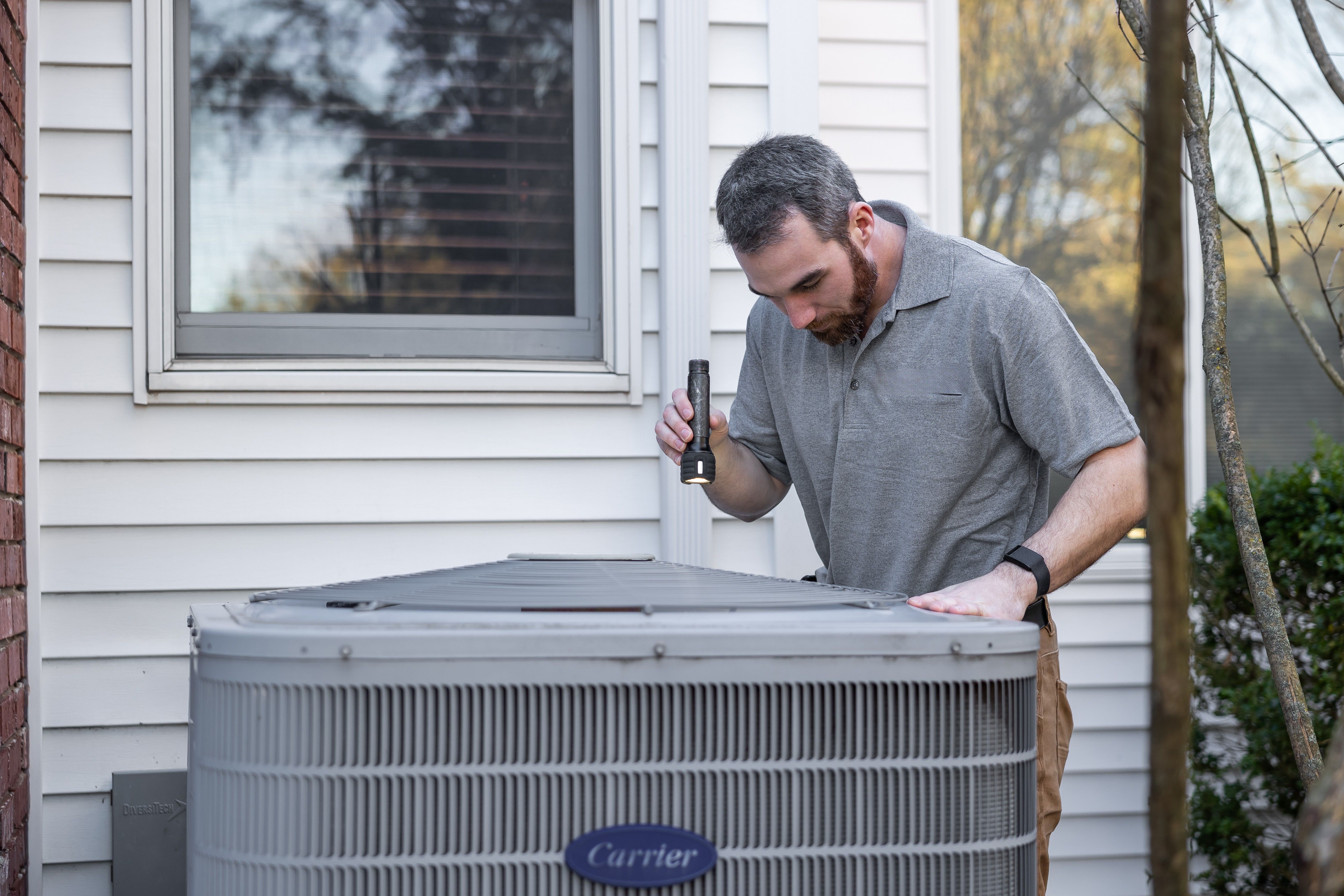 Valley Comfort Pros technician servicing a home AC unit in Draper, Utah